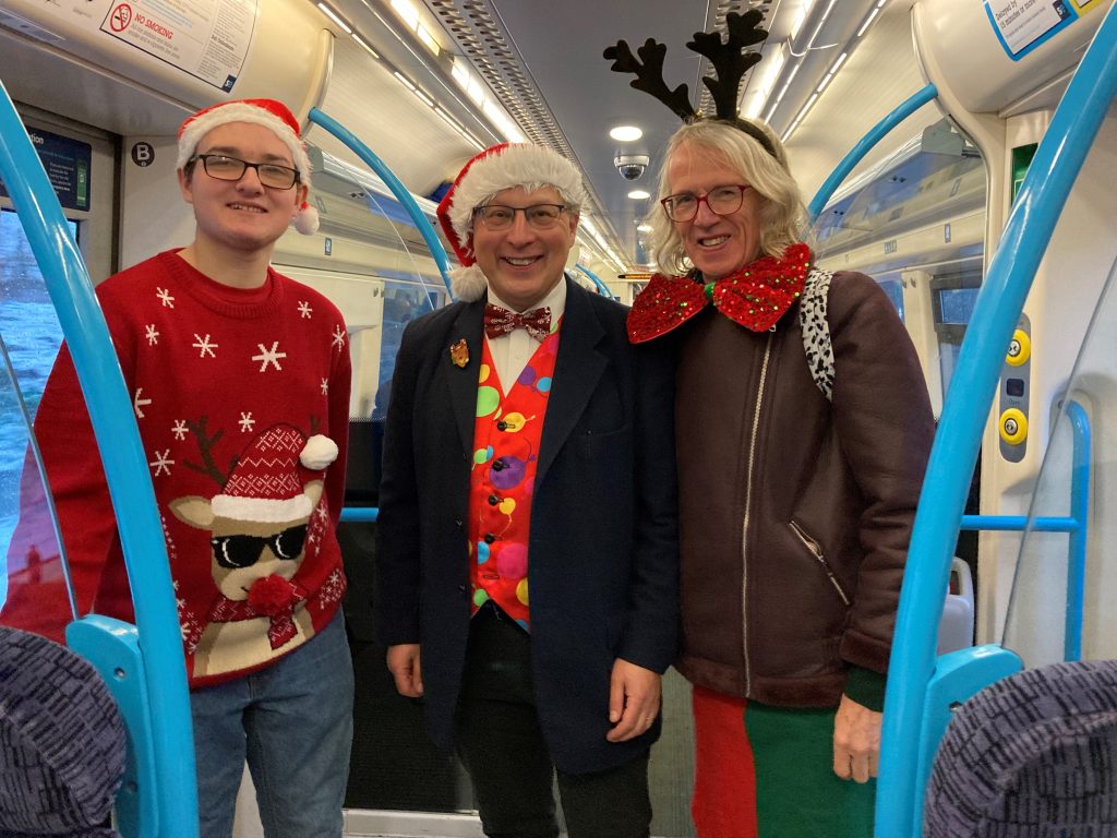 Dominic in his Christmas Jumper and Santa hat, Magic Paul in snazzy waistcoat and santa hat, Dave with his reindeer antlers and super-sized bow-tie.