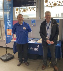 Gary and Matt stood in front of a table full of rail safety information. A4 posters advertise the British Transport Police 61016 text service. A Kent CRP flag stands to one side.