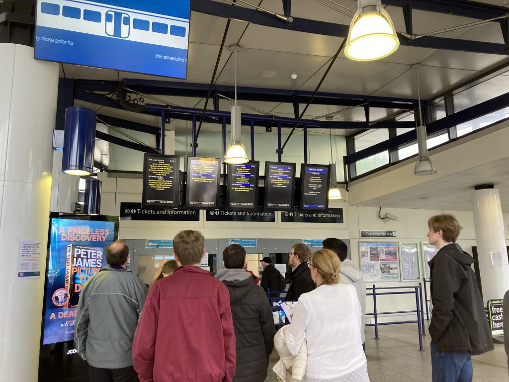 A crowd of students study the departure boards