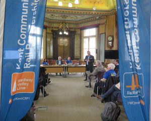 The grand council chamber of Maidstone Town Hall. The picture is framed by Kent Community Rail Partnership banners, Steve White Managing Director of Southeastern is presenting to the room.
