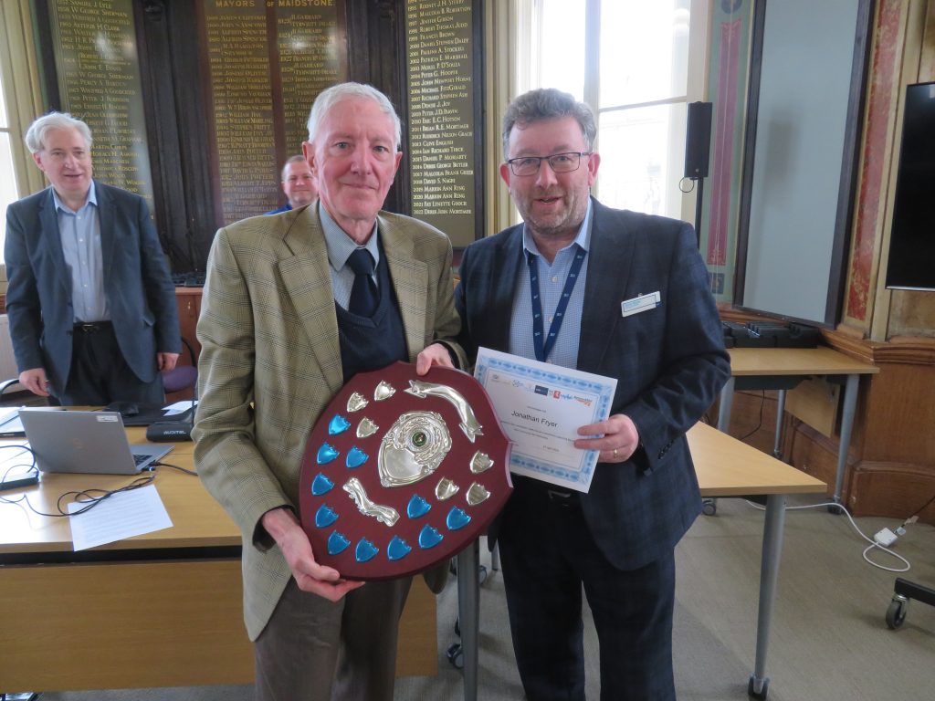 Jonathan Fryer receives his volunteer certificate and the Volunteer of the Year shield from Steve White.