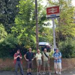 A group of walkers stood beneath the double arrow sign for Halling station
