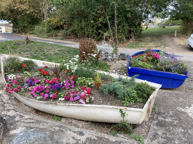Colourful flowers in two rowing boats repurposed as planters