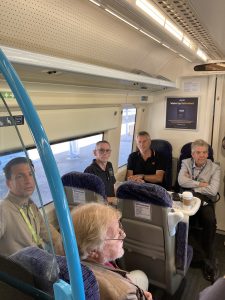 Members on the train listen to a history talk from Jonathan