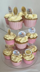A three tier cake stand loaded with delicious looking cup cakes, The cakes have flags of the Kent CRP logo and "20th Anniversary"