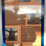 A blue framed noticeboard giving information on local history and attractions.