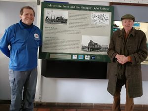 Gary and Jonathan stand either side of a a new information panel outlining the story of Colonel Stephens and the Sheppey Light Railway