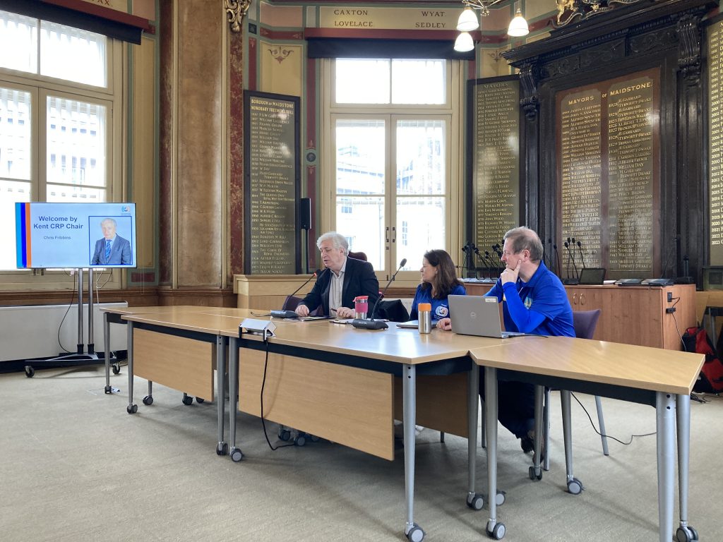 Chris Fribbins, Therese Hammond and Gary Outram seated at the top table in Maidstone Town Hall's council chamber. Chris is delivering his opening remarks to the audience
