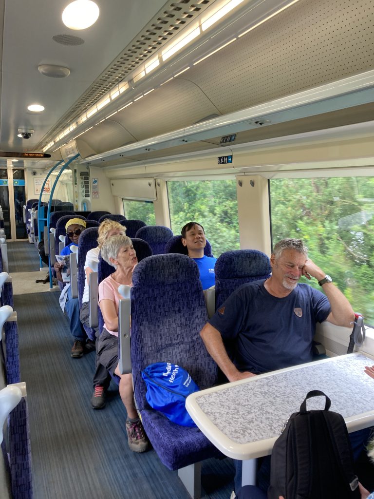 A group of tired walkers seated on a train.
