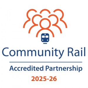 Logo. Stylised outlines of heads and shoulders of a group of people coloured in orange above a train coloured blue. Community Rail Accreited Partnership 2025-26