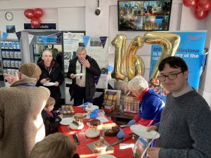 A crowd of people eating cake at Sittingbourne station's 167th birthday celebrations.