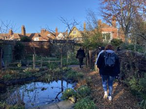 Students walk past a small pnd as they explore the garden