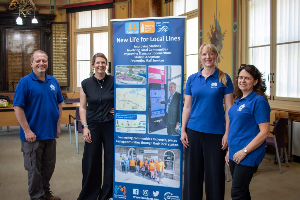 Gary, Clare, Vicky and Therese pose for a picture beside a Kent Community Rail Partnership banner display