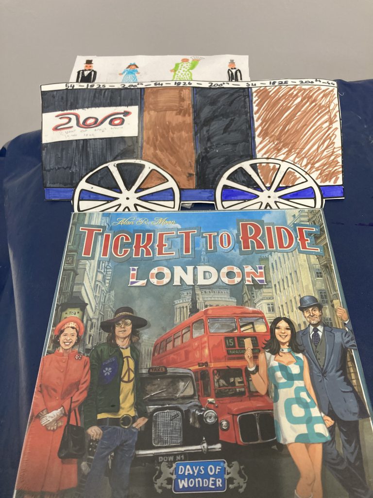 A winning decorated rail carriage and passengers, with the prize of a "Ticket to Ride - London" board game