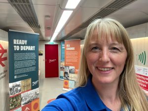 Selfie of Vicky standing in front of a series of roller banners which telll the tale of the railway's relationship with Thanet.