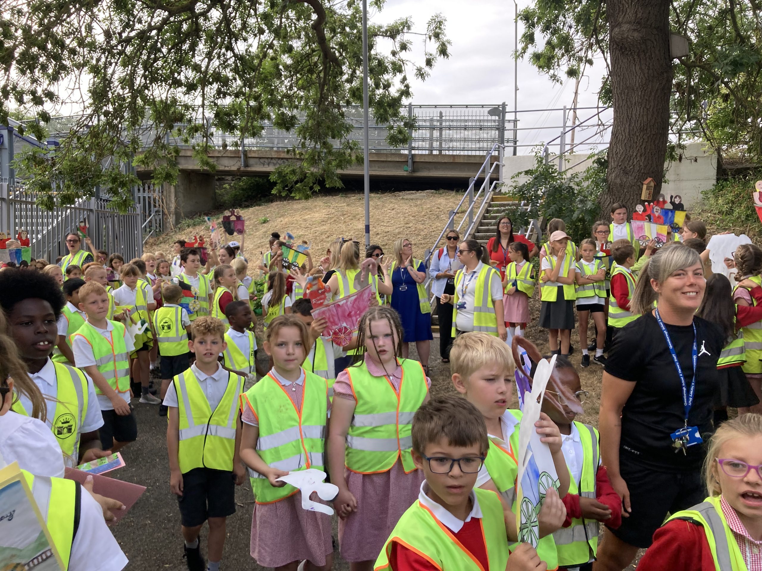 Young learners in hi-vis jackets and their tutors gather for the procession.