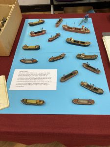 A series of model boats displayed on a plain blue background.