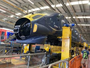 A Southeastern javelin train in the depot shed. The train has been raised from it's bogeys on jacks. People are looking on from behind a safety barrier