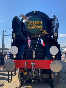 Front view of a steam locomotive with "Colden Arrow" service logo and British and French flags.