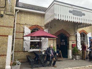 People seated and standing outside the entrance to Hollingbourne station