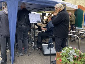 People standing beneath gazebos playing brass instruments.