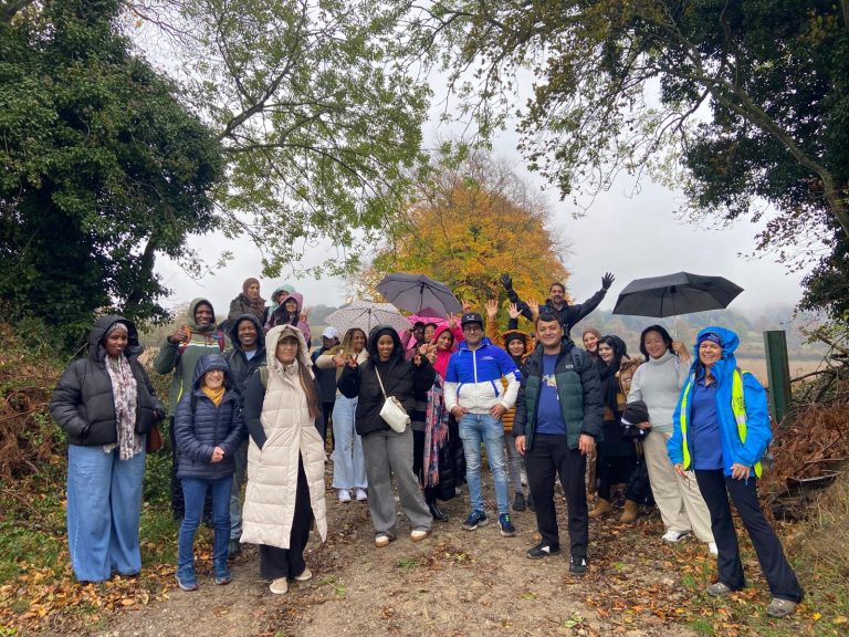 A group of people pose for a picture at the side of a gravel trail.