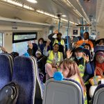 Diversity House Service users waving in a train carriage as we journeyed to Margate