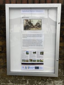 A closed poster cabinet headed "Aylesford Station Adopters" displays a sepia image of the station and details of its history. A poster gives information about places to visit on the Medway Valley Line, Logos of Kent Community Rail Partnership, Aylesford Parish Council, Aylesford Schoo;, Southeastern and Community Rail Network Funded.