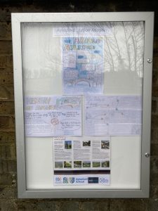 A closed poster cabinet headed "Aylesford Station Adopters" displays student artwork about Aylesford village and its history. A poster gives information about places to visit on the Medway Valley Line, Logos of Kent Community Rail Partnership, Aylesford Parish Council, Aylesford Schoo;, Southeastern and Community Rail Network Funded.