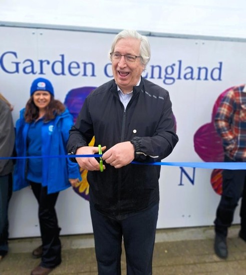 Chris cuts a ribbon as other people look on