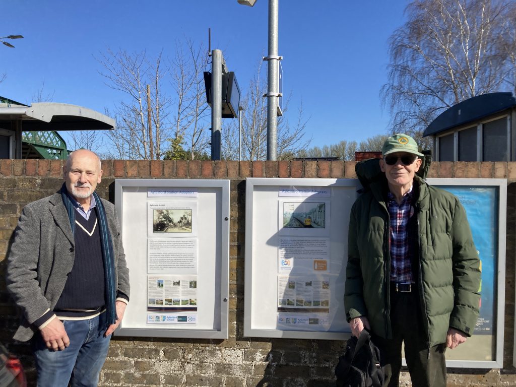Vincent and Tom stand either side of the station history boards.