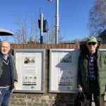 Vincent and Tom stand either side of the station history boards.