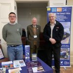 Dominic, Jonathan and Chris at our promotional stall, a variety of leaflets and brochures spread out on the table.