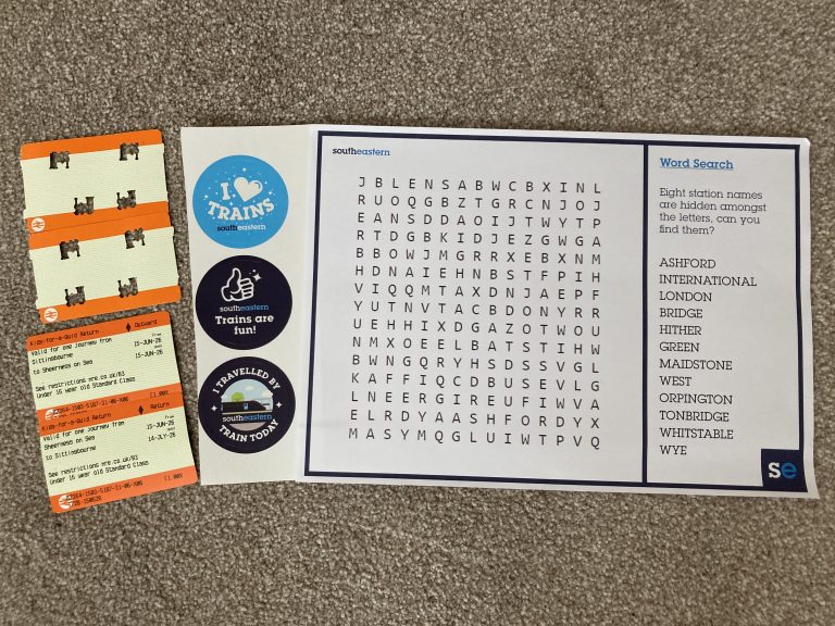 Two blank rail tickets with steam engine shaped holes punched through them, two tickets for a Kids for a Quid return ticket between Sittingbourne and Sheerness. A set of three stickers, "I Love Trains", "Trains are Fun", "I Travelled by Train Today". A word search puzzle with eight station names.