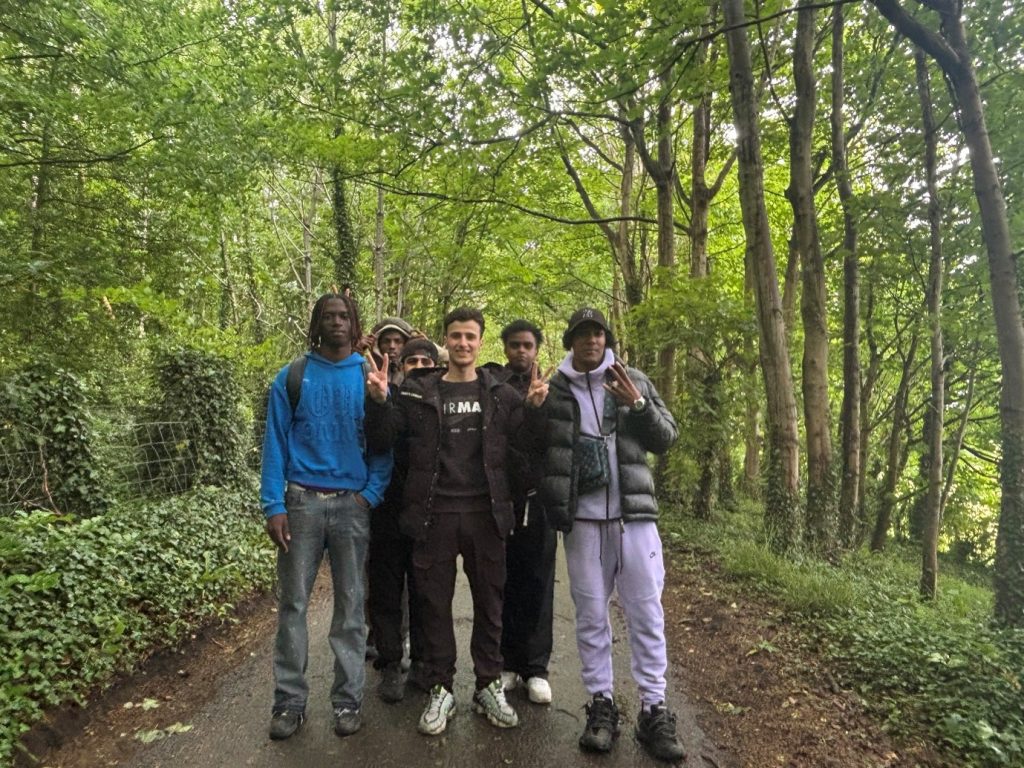 Students walking along a quiet tree-lined road