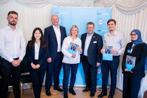 A group of people including, Justine Greening MP, Steve White, Managing Director of Southeastern, and Elliott Frost, Southeastern. They are posing for a picture with Justine and Elliott holding copies of the "On Track to Opportunity" report.