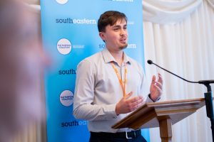 Elliott Frost presents at a lectern