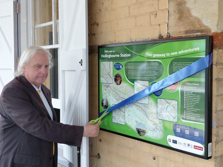 Clive cuts the ribbon across the new information panel at Hollingbourne station