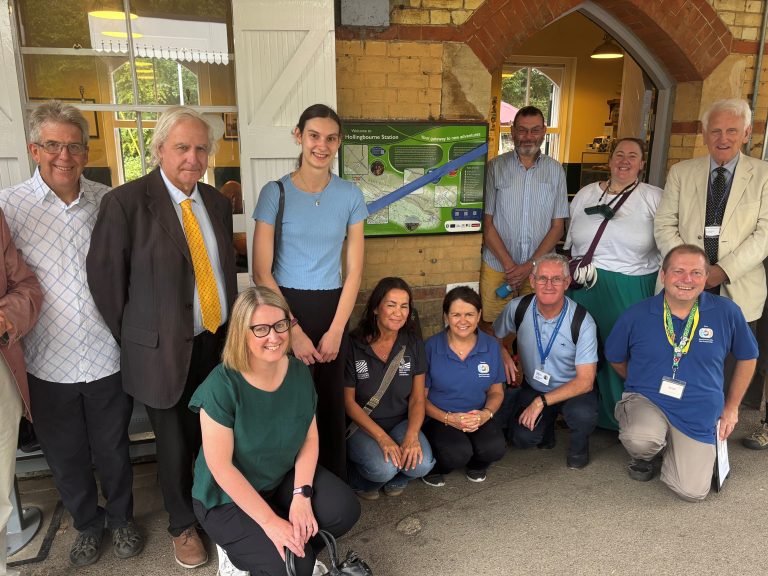 A group of people pose in front of the new information panel at Hollingbourne station. Matt, Clive, jenny, rebecca, Sarah, Therese, Paul, Colin, Kimmy, Gary, Denis