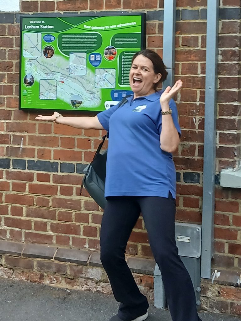 Therese poses excitedly by the information board at Lenham station