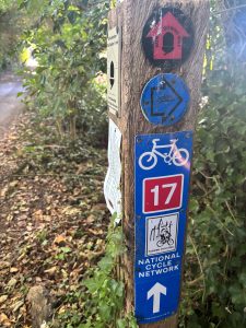 A wooden post bearing a variety of trail waymarkers.